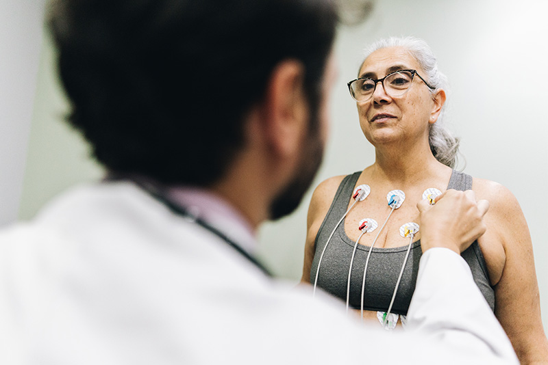 Doctor places sensors on woman's chest for stress test