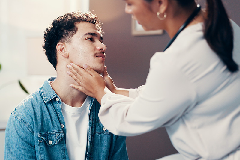 Doctor inspecting a man's thyroid gland