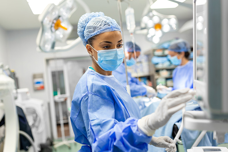 O.R. nurse adjusting monitor during a procedure