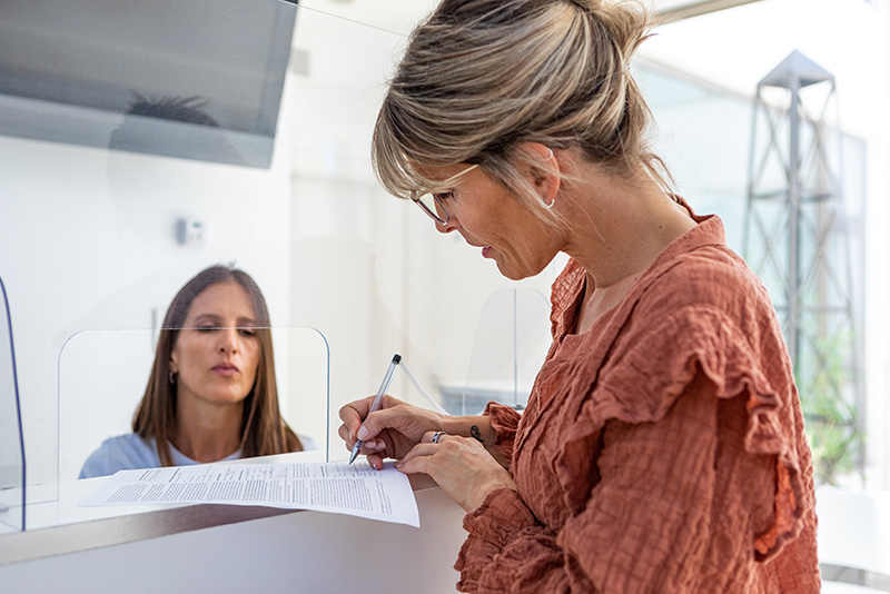 Woman filling out a form in the waiting room of a doctor's office
